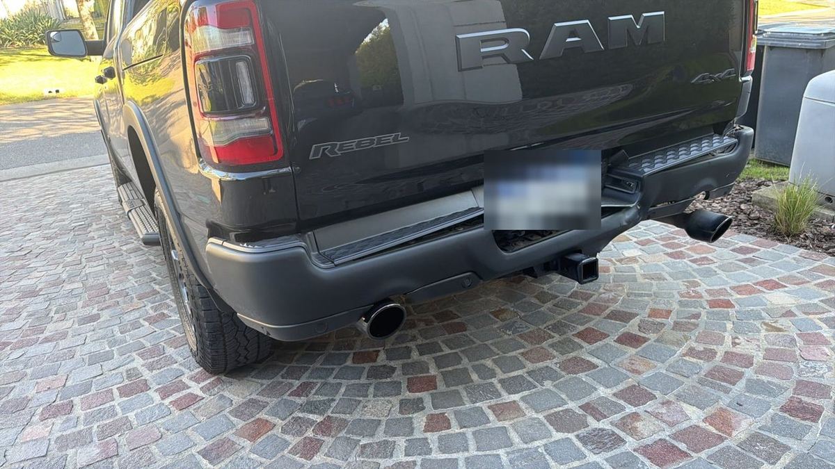 Antes: RAM Rebel negra con el paragolpes trasero golpeado